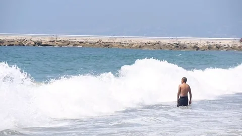 Man Wading in Ocean Stock Footage