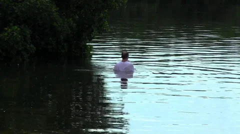 Man wading into river to fish Stock-Footage 30436911