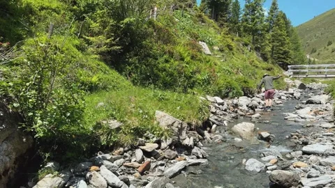 Man Wading through Pristine Alpine Stream in Austrian Alps in Slow Motion Stock Footage 332713656