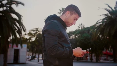 Man waiting and killing or spending time playing with smartphone or mobile phone Stock Footage 101489555