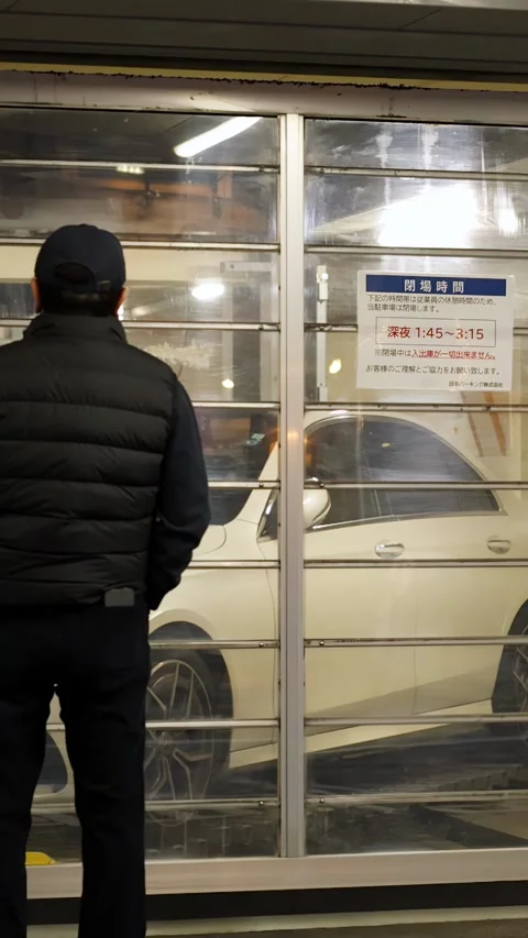 Man Waiting at Automated Car Elevator in Tokyo Parking Garage Stock Footage 343599956
