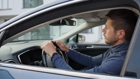 Man waiting in car, looking around and checking phone Stock Footage 340490580