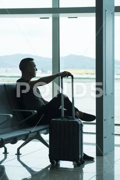 Man waiting for his flight in an airport Stock Photos