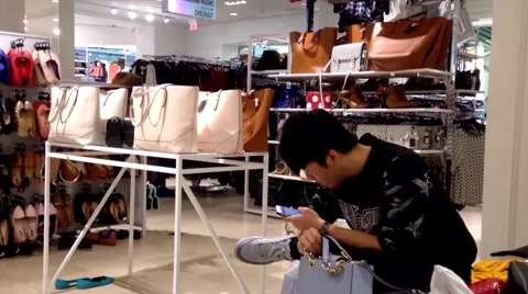 Man waiting his girlfriend and reading phone message inside Forever 21 store Stock Footage 53051674