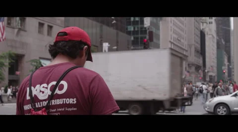 Man waiting at intersection for traffic to clear Vidéo 57095428