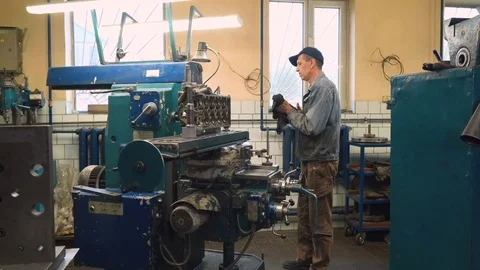 Man waiting for milling of cylinder head on machine, cleaning hands Video stock 81536053
