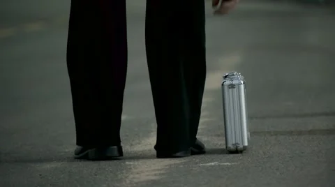Man waiting on the side of the road with a suitcase Stock Footage 7904036