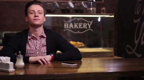 Man waiting for someone at a table in the cafe, woman comes and they greet each Stock-Footage 61217141