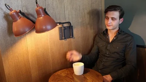 Man waiting for someone while drinking coffee Stock Footage 83252406