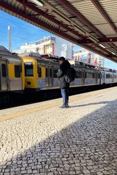 A man waiting for a train on the platform of Lisbon station, Portugal Stock Photos