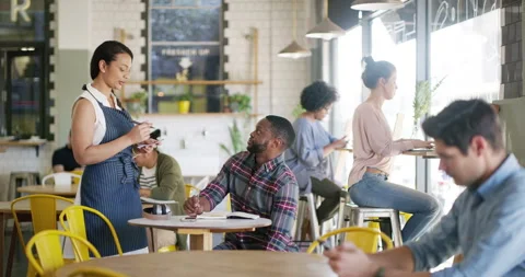 Man, waitress and talking in cafe for hospitality, friendly service and Stock Footage 345810509