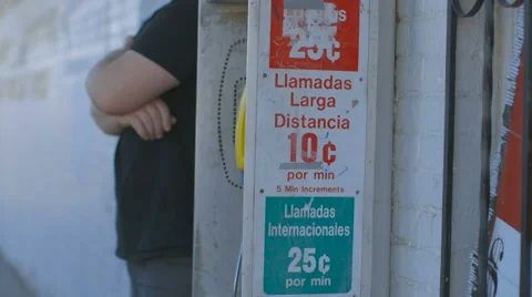 Man Waits by Pay Phone in Border Town Stock Footage 60128999