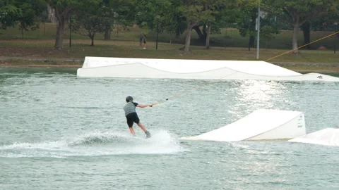 Man Wakeboarding and Performing Jumps at a Cable Ski Park Stock-Footage 328488377