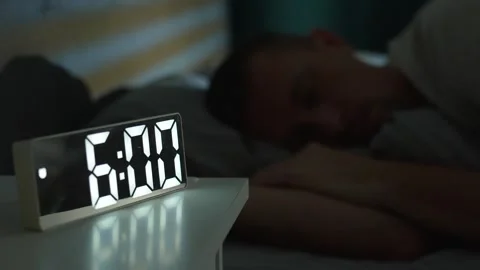 Man waking up at 6 a.m with digital alarm clock Video stock 294311711