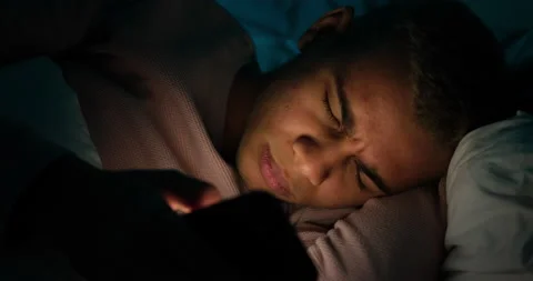 Man waking up and checking his mobile phone late night in bed Stock Footage 145291351