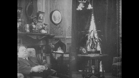 Man waking up and talking to two people, United Kingdom, 1913 Video stock 136680586