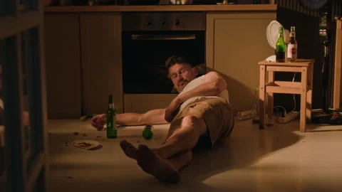 Man Waking on Floor Drinking Beer Suffering from Alcohol Abuse at Home Stock Footage 344873258