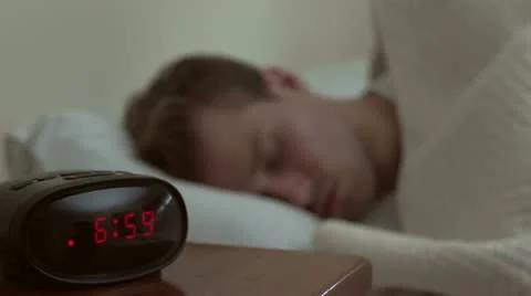 Man waking up to his alarm Stock-Footage 12007413