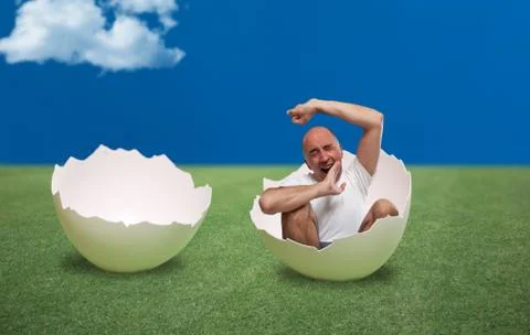 Man waking up inside an egg Stock Photos