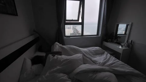 A man waking up, sit on the bed looking at the beautiful view in the window. Stock Footage 163740234