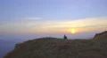The man walk on the mountain on the background of sunset. Real time capture 4k or 4k+ Resolution