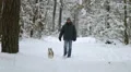 The man walk in the snowy forest with a Husky. Real time capture 4k or 4k+ Resolution