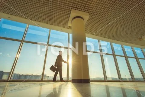 The man walk with a suitcase in the office hall Stock Photos