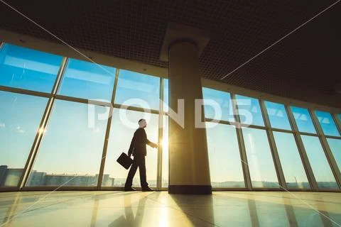 The man walk with a suitcase in the office hall Stock Photos