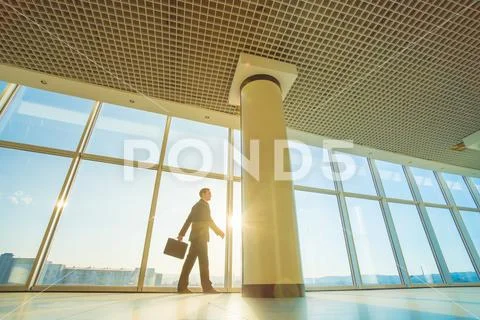 The man walk with a suitcase on the sunshine background Stock Photos