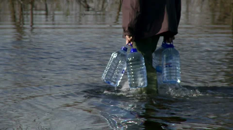 Man walk through the water and carrying water supplies in flooded area Stock Footage