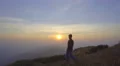 The man walk on the top of the mountain against the background of sunrise 4k or 4k+ Resolution