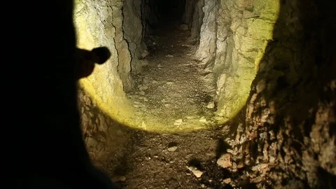 Man Walking into Abandoned Mine with Flashlight or Torch Stock Footage 122903616