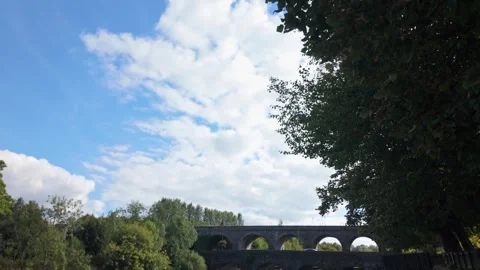 Man Walking Across Bridge Over River Maine with Randalstown Viaduct 動画素材 317649061