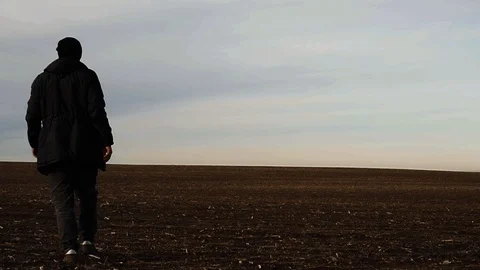 A man is walking across an endless field Stock Footage 102613853