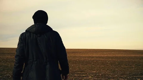 A man is walking across an endless field Stock Footage 102613857