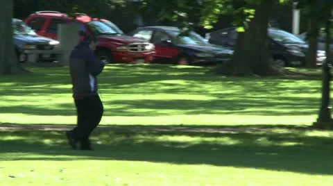 Man walking across the park Stock Footage 10685254