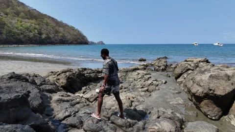 Man walking across rocks Stock Footage 261981524