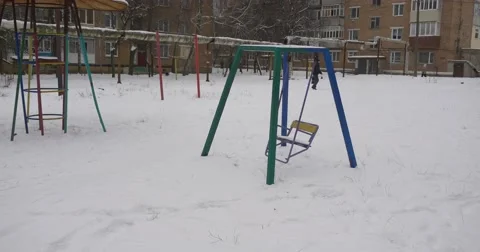 Man is Walking Across a Yard Swing is Swinging Sandbox Playground Equipment Video stock 58821520
