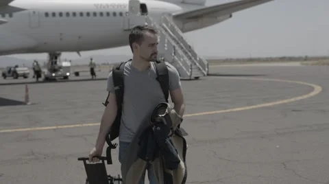 Man Walking from Airplane With Backpack Stock Footage 60438223