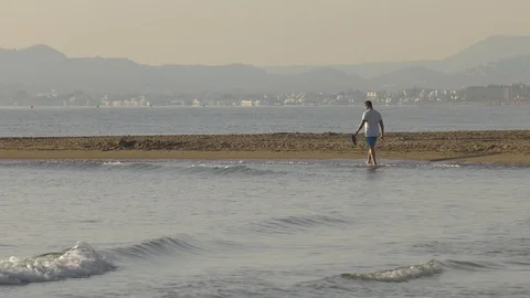 Man Walking Alone On Beach In Early Morning Video stock 117413968