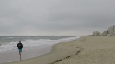 Man walking alone on beach Stock Footage 38687805