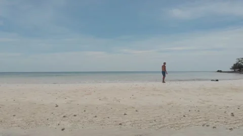 Man walking alone on the beach Stock Footage 260432044