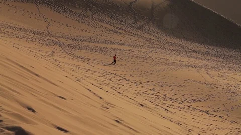A man walking alone in desert Stock Footage 77091349