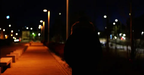 Man Walking Alone at Night Under Streetlights Stock Footage 299638506