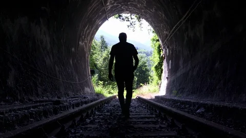 Man walking alone out Railway Tunnel Stock Footage 97399314