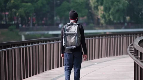 Man Walking Alone in a Park with a Backpack, Enjoying the Quiet and Nature A Video stock 298864701