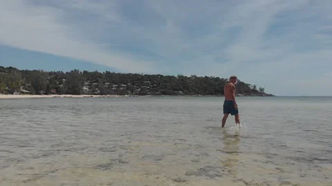 Man walking alone into the sea Stock Footage 260431864