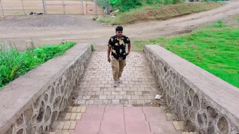 Man walking alone on a stone bridge in a park dressed in black with greener.. Stock Footage 262130784