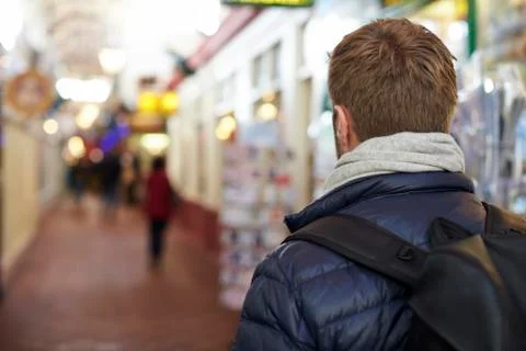 Man Walking Along Arcade Of Shops In Town Centre Stock Photos