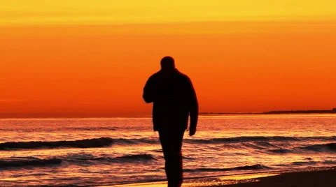 A man walking along the beach Stock Footage 32354744
